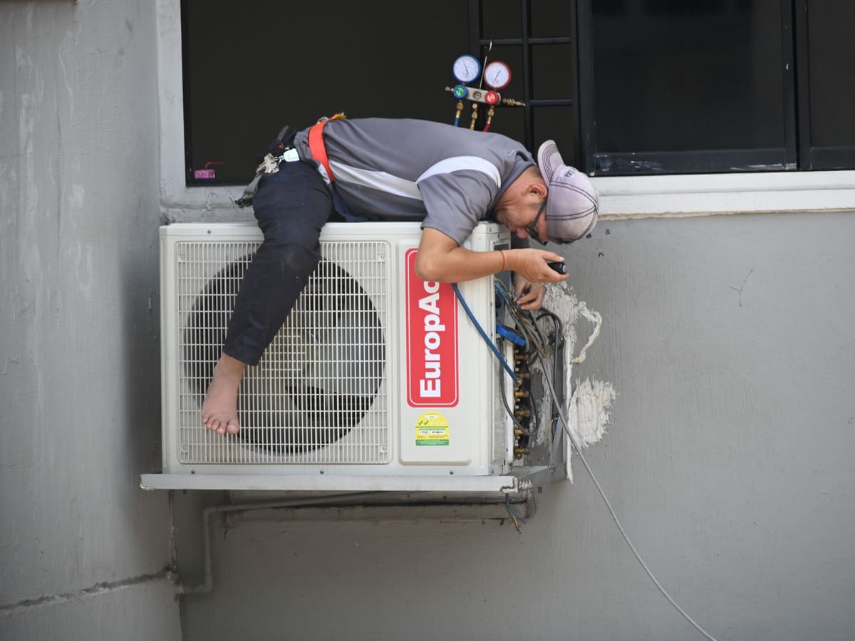 Técnico trabajando en la unidad exterior de un equipo de aire